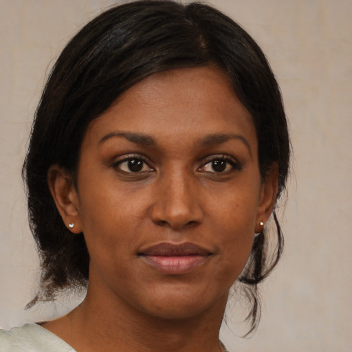 Joyful black young-adult female with medium  brown hair and brown eyes