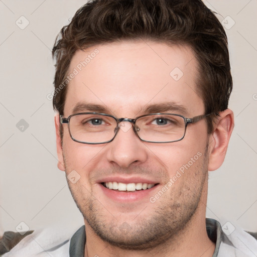 Joyful white young-adult male with short  brown hair and grey eyes