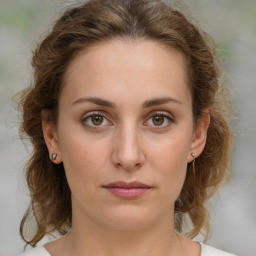 Joyful white young-adult female with medium  brown hair and green eyes