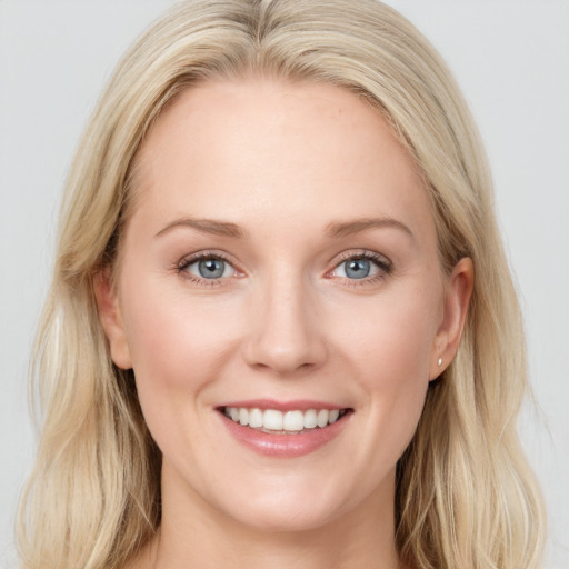 Joyful white young-adult female with long  brown hair and blue eyes