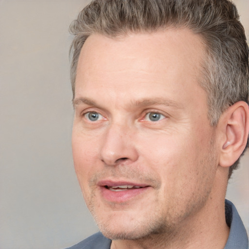 Joyful white adult male with short  brown hair and grey eyes