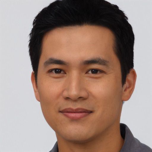 Joyful asian young-adult male with short  black hair and brown eyes
