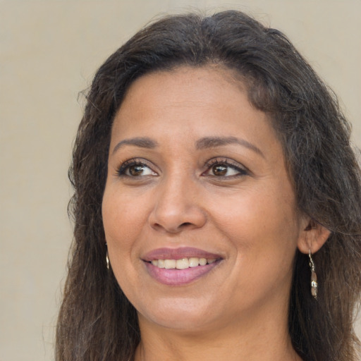 Joyful latino adult female with long  brown hair and brown eyes
