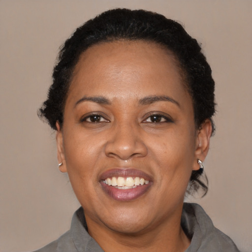 Joyful black adult female with short  black hair and brown eyes