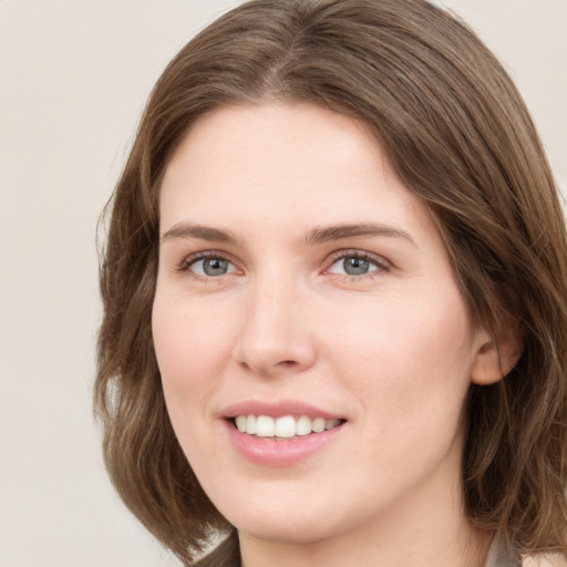 Joyful white young-adult female with medium  brown hair and green eyes