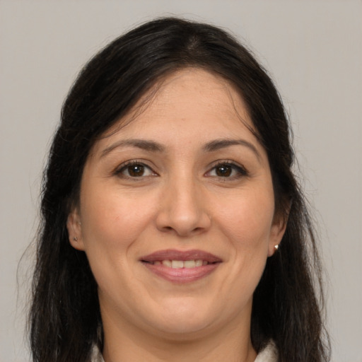 Joyful white adult female with long  brown hair and brown eyes