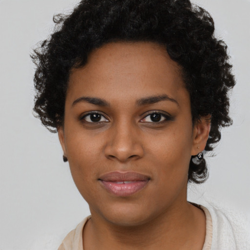 Joyful black young-adult female with short  black hair and brown eyes