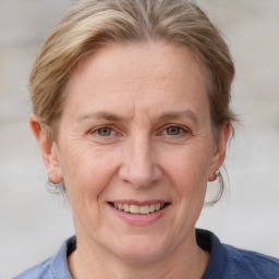 Joyful white adult female with medium  brown hair and blue eyes