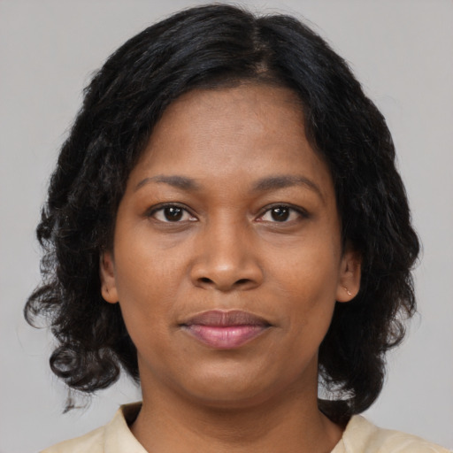 Joyful black adult female with medium  brown hair and brown eyes