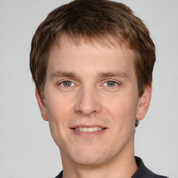 Joyful white young-adult male with short  brown hair and grey eyes