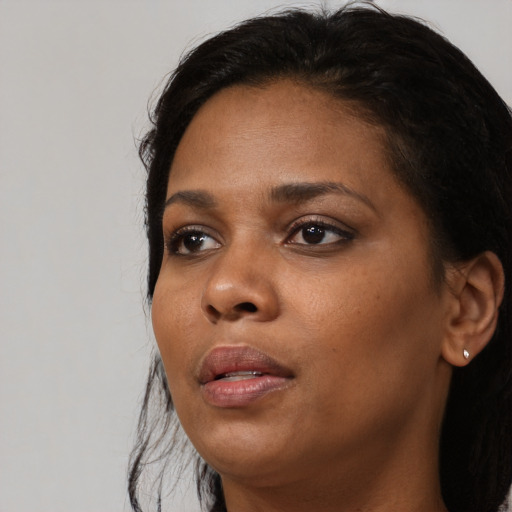 Joyful black adult female with medium  black hair and brown eyes