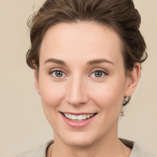 Joyful white young-adult female with short  brown hair and green eyes