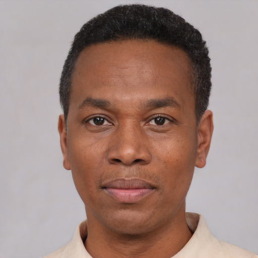 Joyful black young-adult male with short  black hair and brown eyes