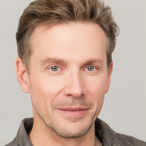 Joyful white adult male with short  brown hair and grey eyes