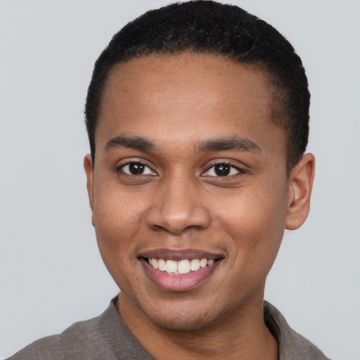 Joyful black young-adult male with short  brown hair and brown eyes