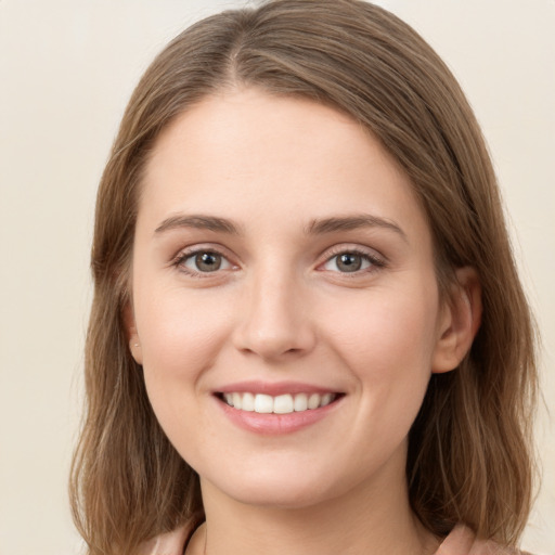 Joyful white young-adult female with medium  brown hair and green eyes