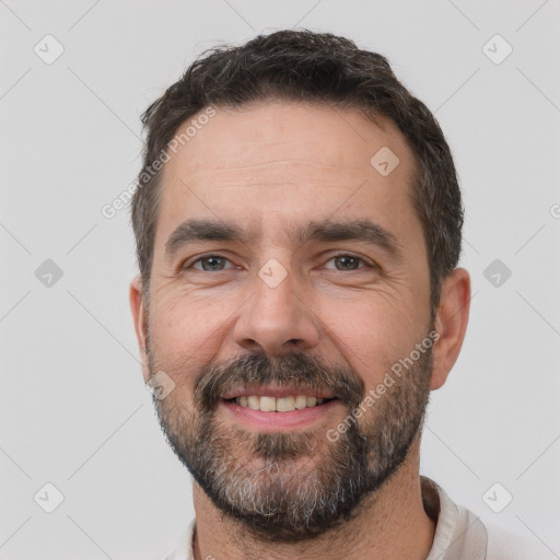 Joyful white adult male with short  black hair and brown eyes