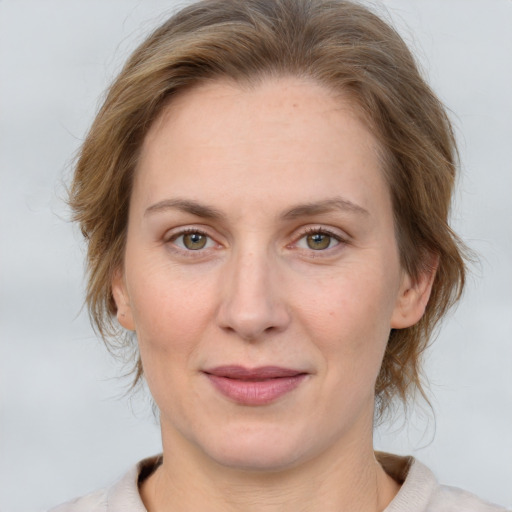 Joyful white adult female with medium  brown hair and green eyes