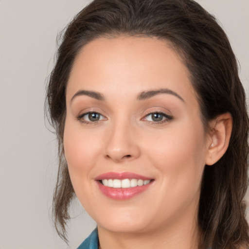 Joyful white young-adult female with long  brown hair and brown eyes