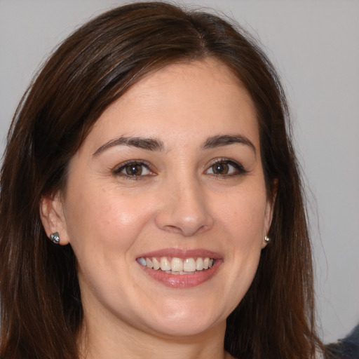 Joyful white young-adult female with long  brown hair and brown eyes