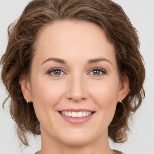 Joyful white young-adult female with medium  brown hair and green eyes