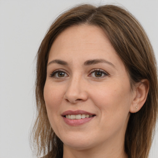 Joyful white adult female with long  brown hair and brown eyes