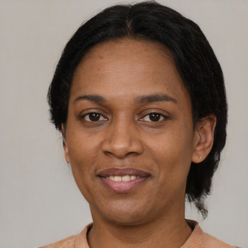 Joyful black adult female with short  black hair and brown eyes