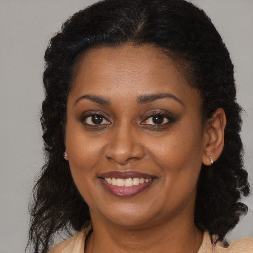 Joyful black young-adult female with medium  brown hair and brown eyes