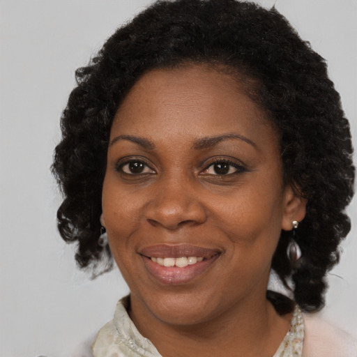 Joyful black adult female with medium  brown hair and brown eyes