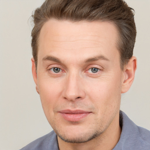 Joyful white adult male with short  brown hair and grey eyes