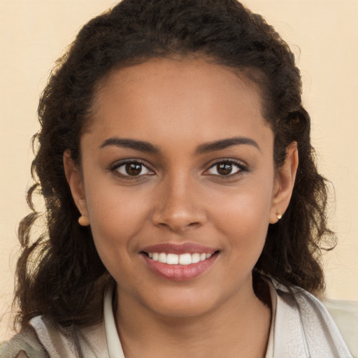 Joyful black young-adult female with long  brown hair and brown eyes