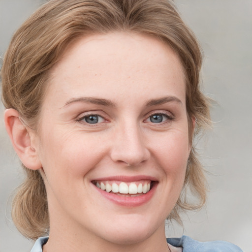 Joyful white young-adult female with medium  brown hair and blue eyes