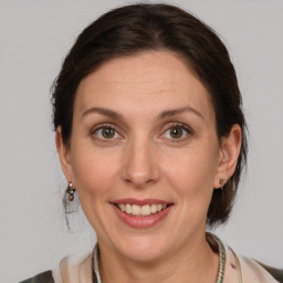 Joyful white adult female with medium  brown hair and grey eyes