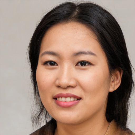 Joyful asian young-adult female with long  brown hair and brown eyes