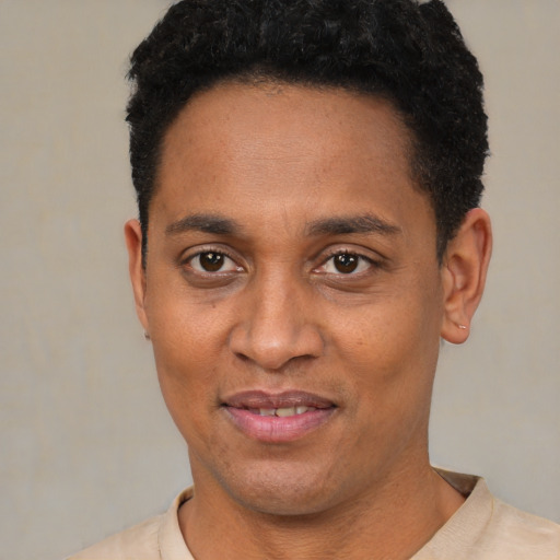 Joyful black adult male with short  black hair and brown eyes