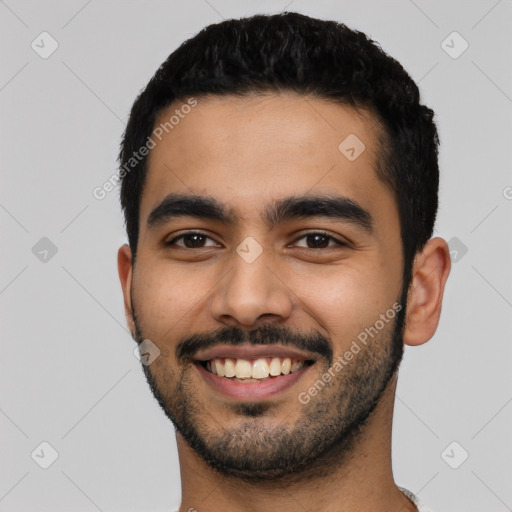 Joyful latino young-adult male with short  black hair and brown eyes