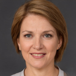 Joyful white adult female with medium  brown hair and grey eyes