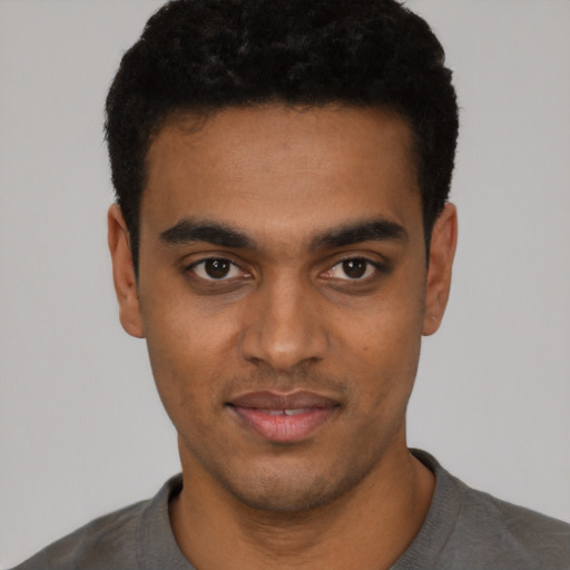 Joyful black young-adult male with short  black hair and brown eyes