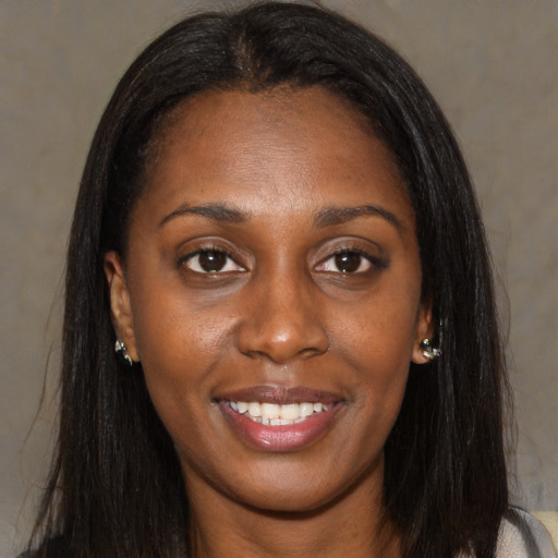 Joyful black young-adult female with long  brown hair and brown eyes