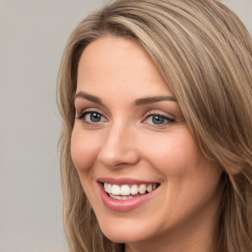 Joyful white young-adult female with long  brown hair and green eyes