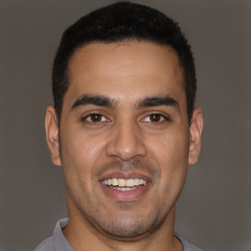Joyful latino young-adult male with short  brown hair and brown eyes
