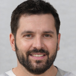 Joyful white adult male with short  brown hair and brown eyes