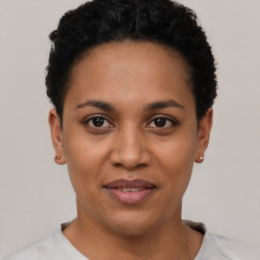 Joyful black young-adult female with short  black hair and brown eyes