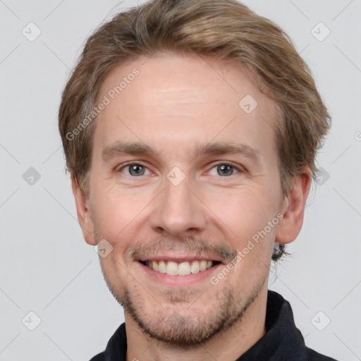 Joyful white adult male with short  brown hair and grey eyes