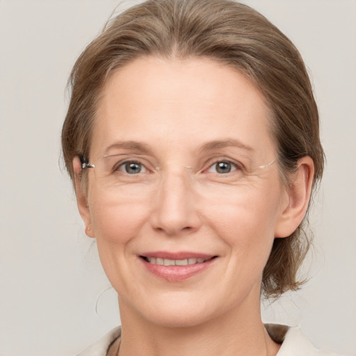 Joyful white adult female with medium  brown hair and grey eyes