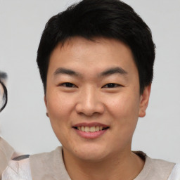 Joyful asian young-adult male with short  black hair and brown eyes