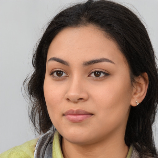 Joyful latino young-adult female with long  brown hair and brown eyes