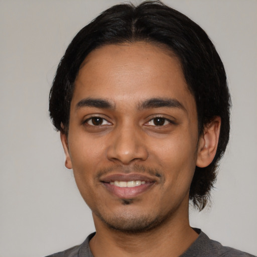 Joyful latino young-adult male with short  black hair and brown eyes