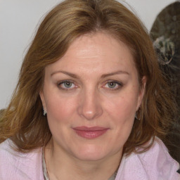 Joyful white adult female with medium  brown hair and blue eyes