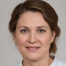 Joyful white adult female with medium  brown hair and grey eyes